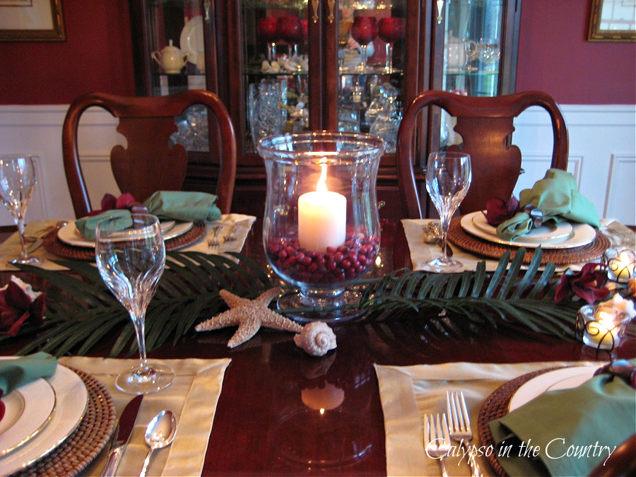 Christmas tablescape with glass hurricane candle centerpiece