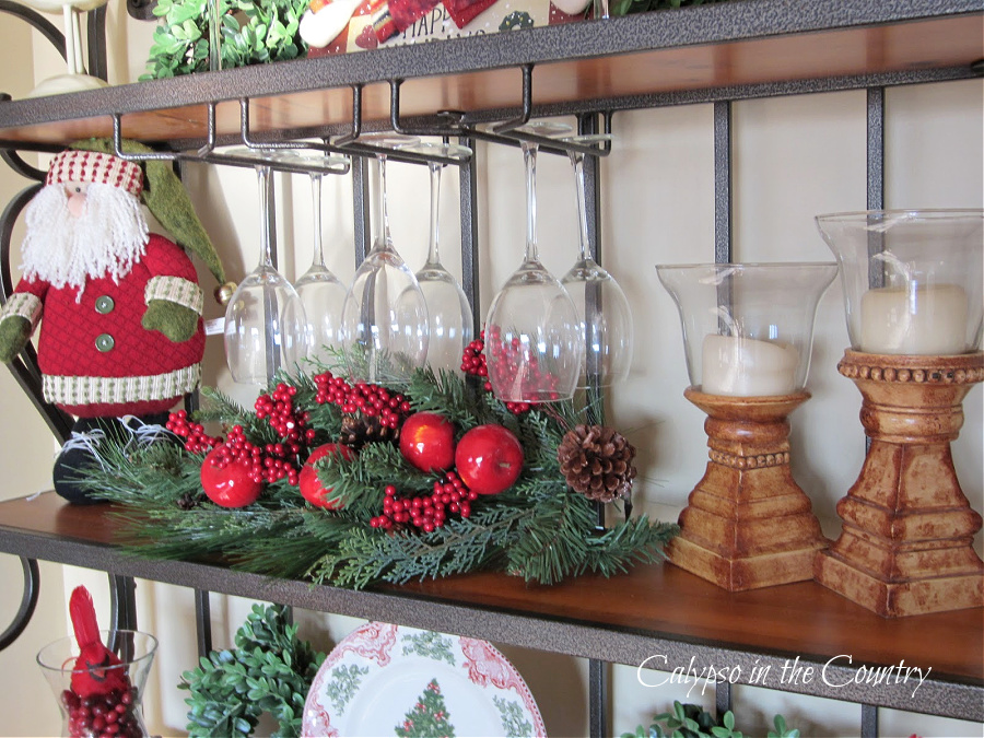 Santa and red Christmas decorations on bakers rack shelf