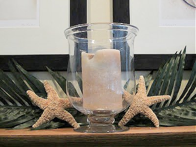 Candle with glass hurricane and starfish on mantel - tropical style decor 