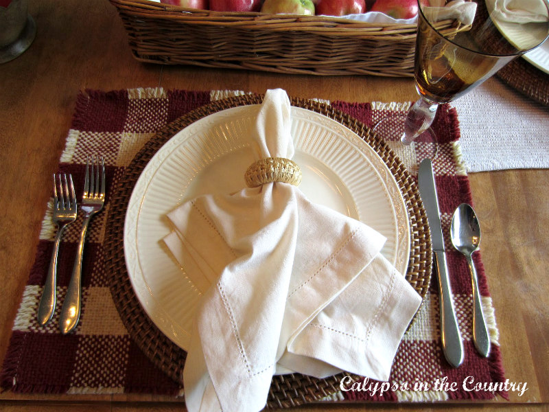 fall place setting with white napkin and red and white buffalo checked place mat