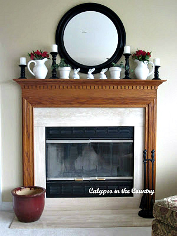 oak fireplace mantel with round mirror above - simple spring mantel with bunnies and flowers