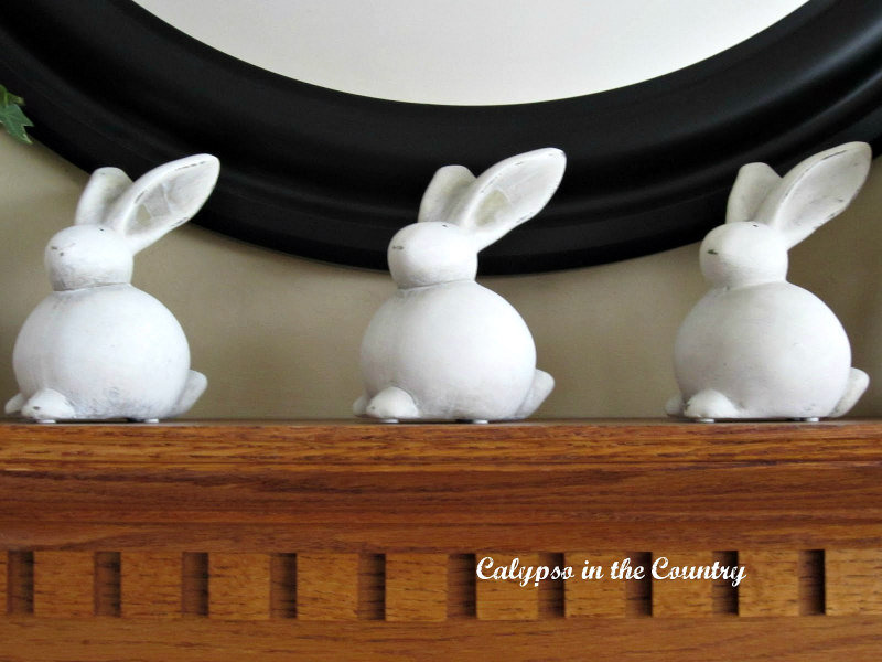 Three ceramic bunnies on fireplace mantel