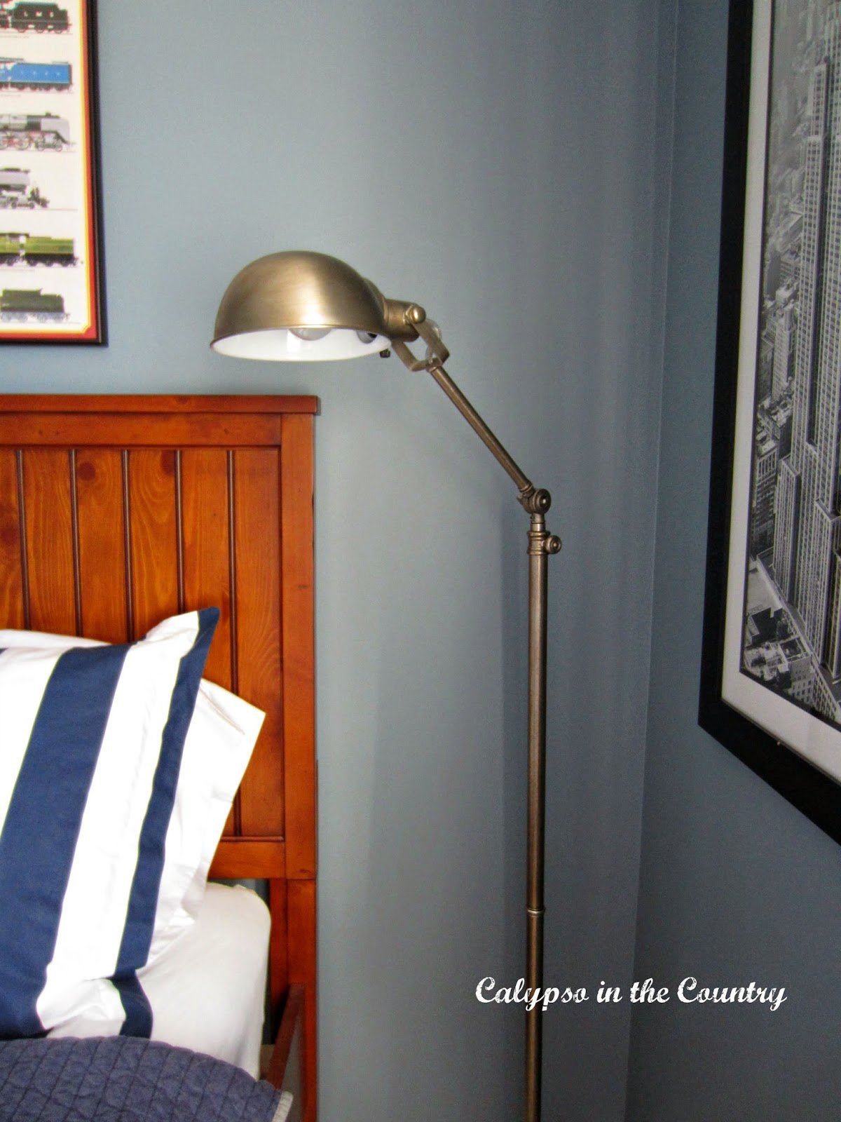 Apothecary floor lamp next to bed in blue boys room