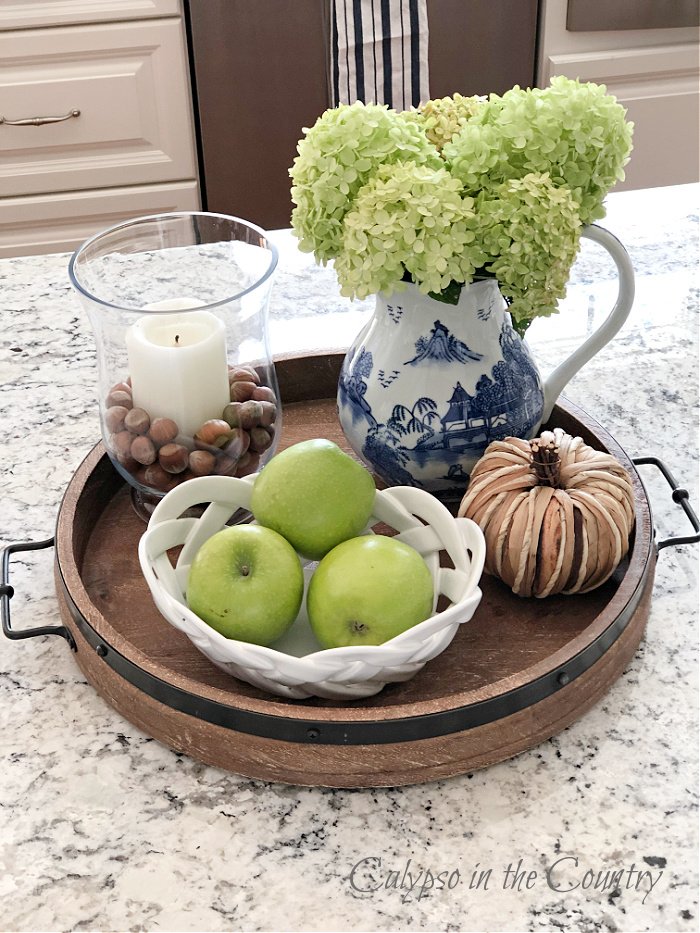 Round wood tray with green apples and hydrangeas