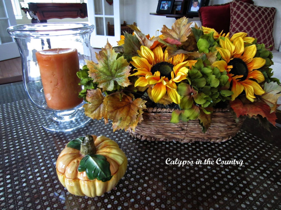 Basket of sunflowers and candle on table 