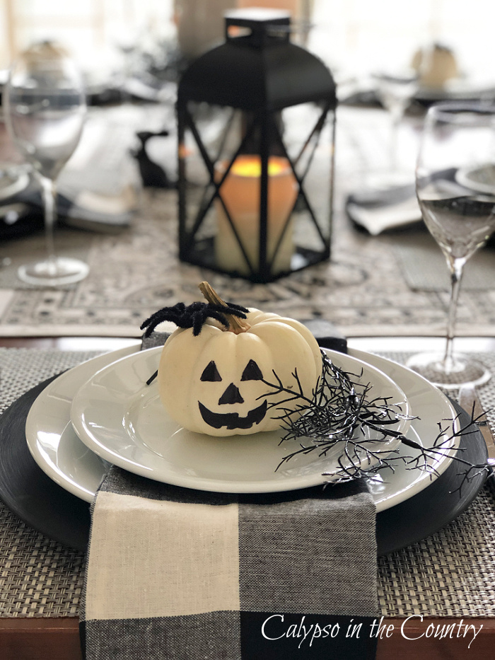 White jack-o-lantern on black and white Halloween table setting - Decorating with white pumpkins