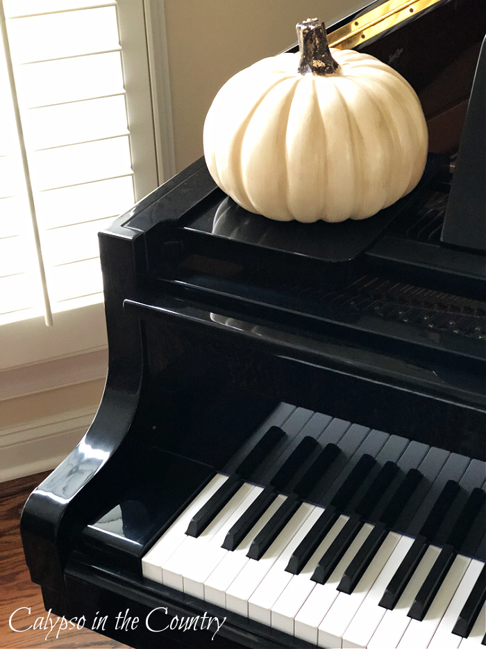 White pumpkin on black piano - decorating with white pumpkins