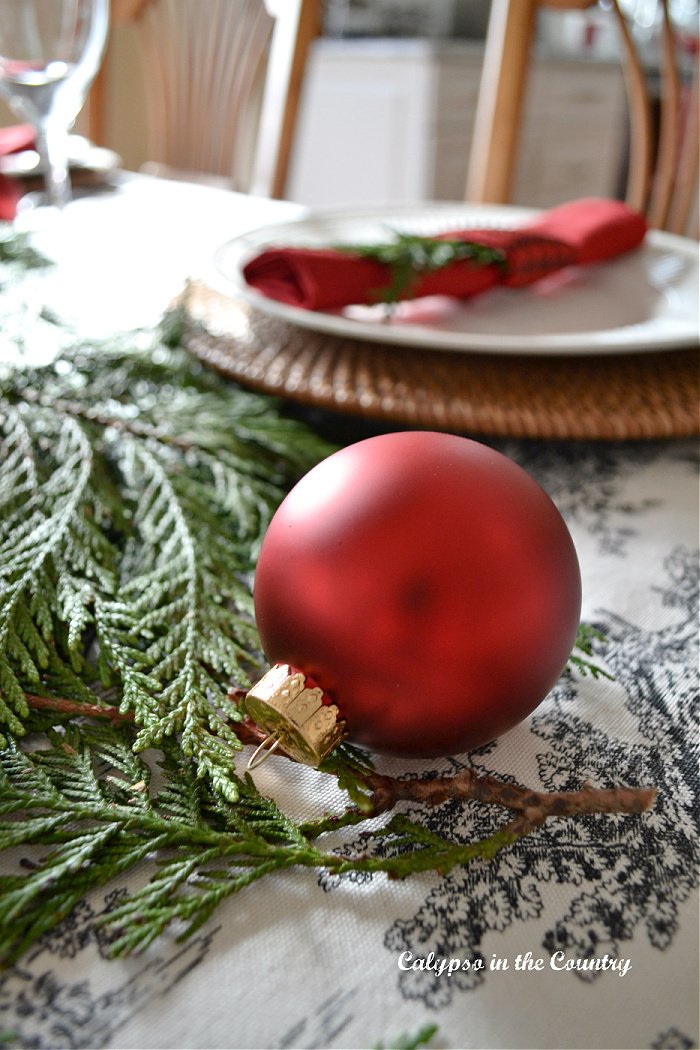 red ornament on toile tablecloth - red and black Christmas table