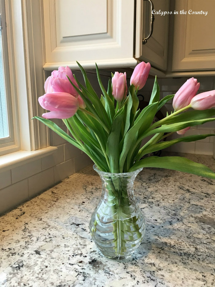 pink tulips in crystal vase