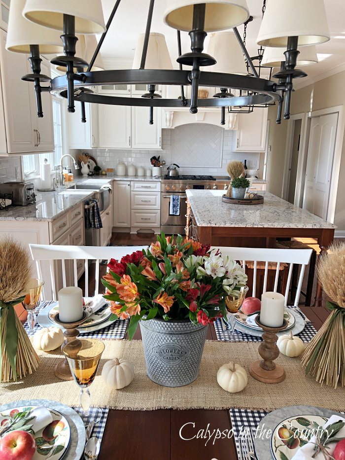Fall table with colorful flower centerpiece and apple place settings - decorating with apples