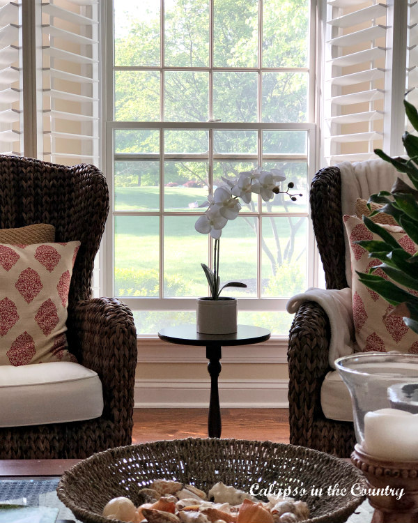 Open plantation shutters in traditional living room.