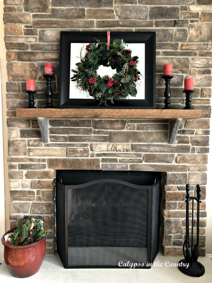 stone fireplace with rustic mantel decorated for Christmas