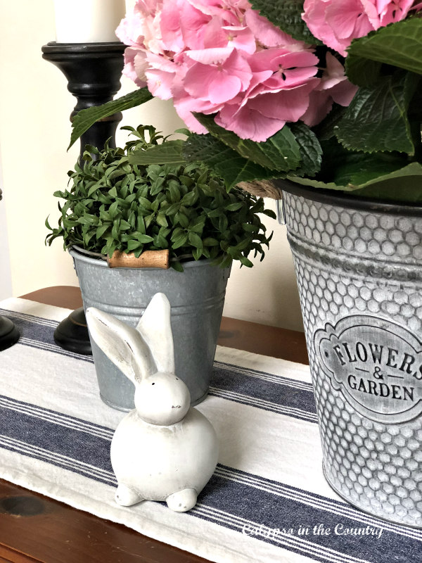 white bunny and spring flowers on console table - decorating with pink hydrangeas