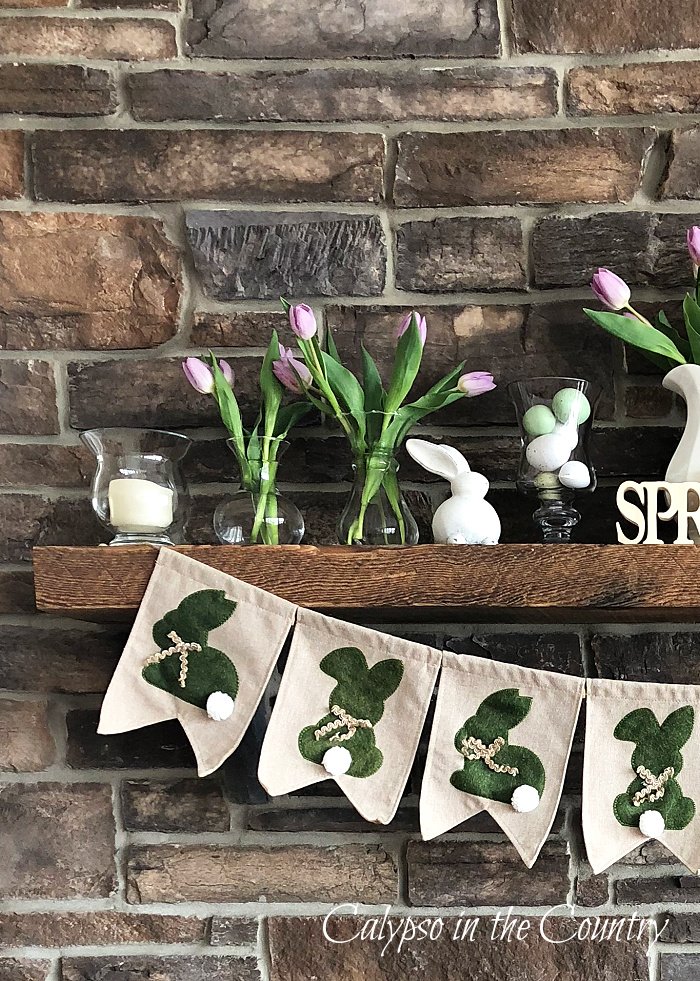 stone fireplace with bunny banner and tulips - spring fireplace decor ideas