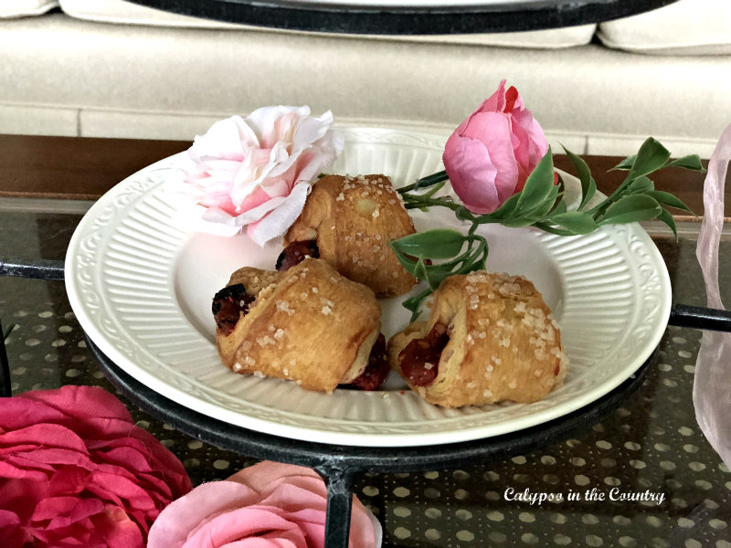 pink roses and pastries on plate for spring tea party