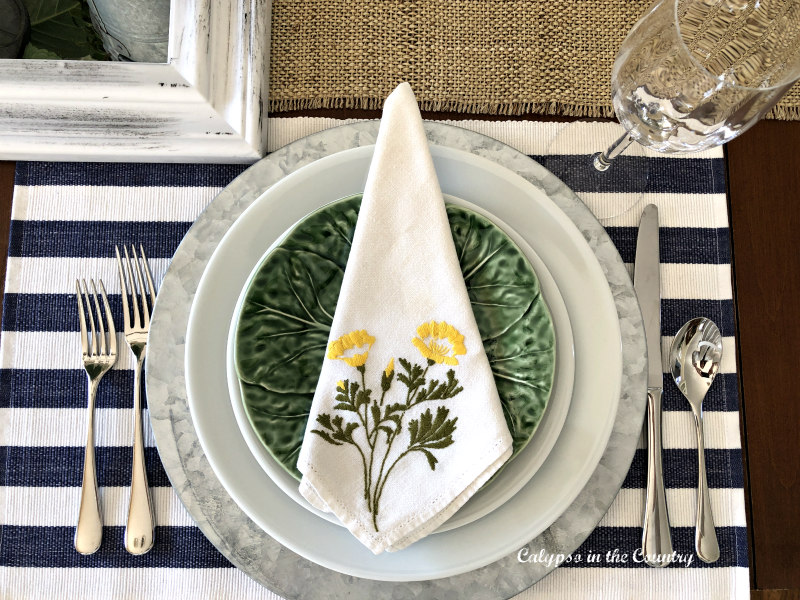 Floral napkin on blue and green spring place setting