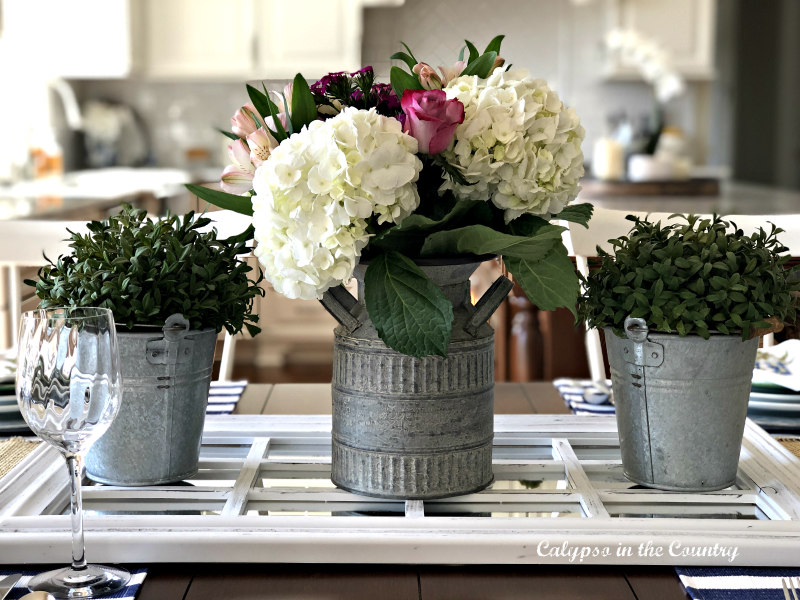 table centerpiece with spring flowers in galvanized containers