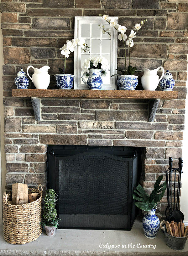 Rustic stone fireplace with blue and white accessories on mantel