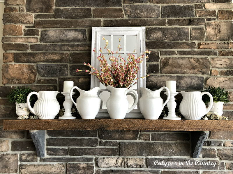 white pitchers on rustic farmhouse style mantel - ways to decorate your mantel for spring