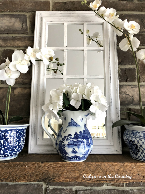 window pane mirror on mantel with blue and white accessories