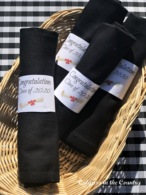 Basket of rolled black napkins with paper napkin bands - Easy DIY napkin rings.