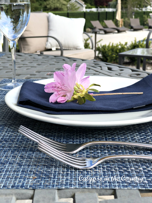 Blue place setting with purple flower from the garden