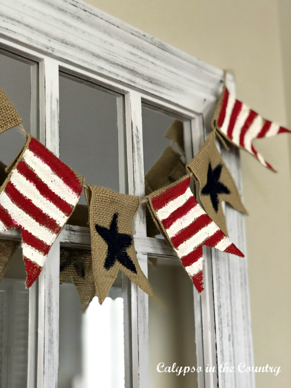 DIY patriotic banner hung on window pane mirror - ideas for cheap patriotic decor.