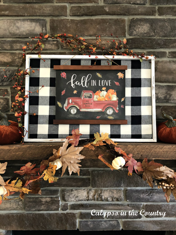 Buffalo Check sign on fall fireplace with fall garland and velvet pumpkins