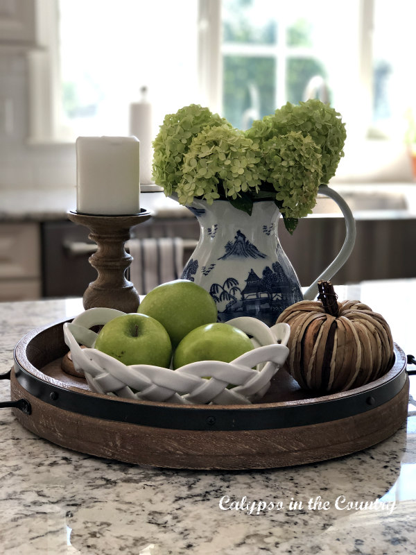 Round tray vignette with hydrangeas and green apples on the kitchen island