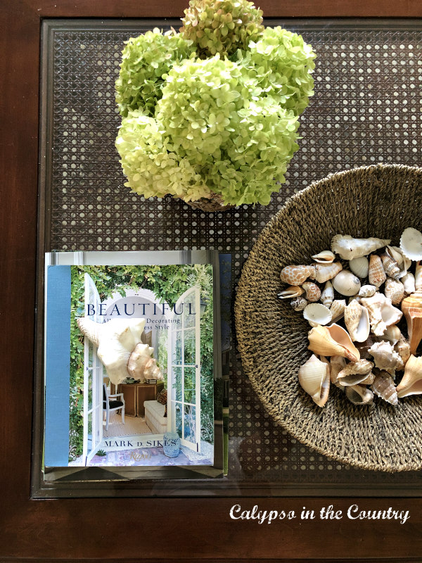 hydrangeas and shells on cane coffee table - early fall decorating ideas