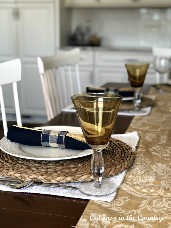 Amber wine glasses on a blue and gold fall table