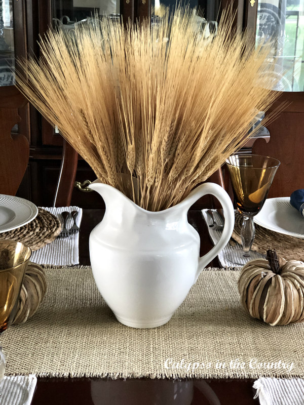 Wheat in white pitcher centerpiece for autumn