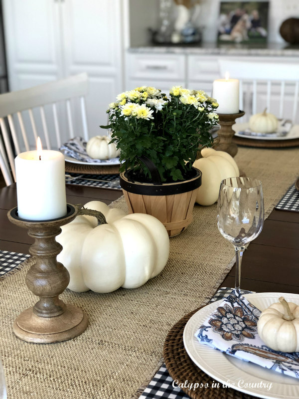 White pumpkins, mums and candles on burlap runner - ideas for fall table decor