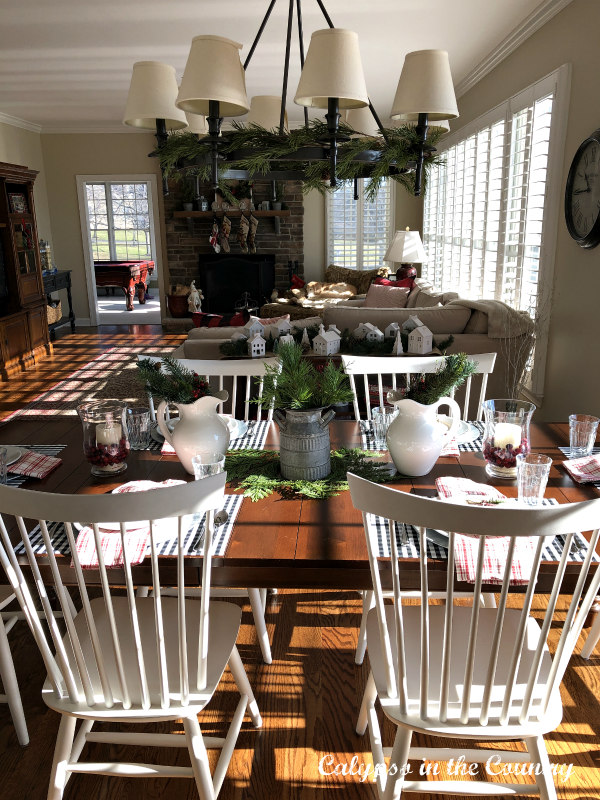 Farm table with white chairs in open concept kitchen