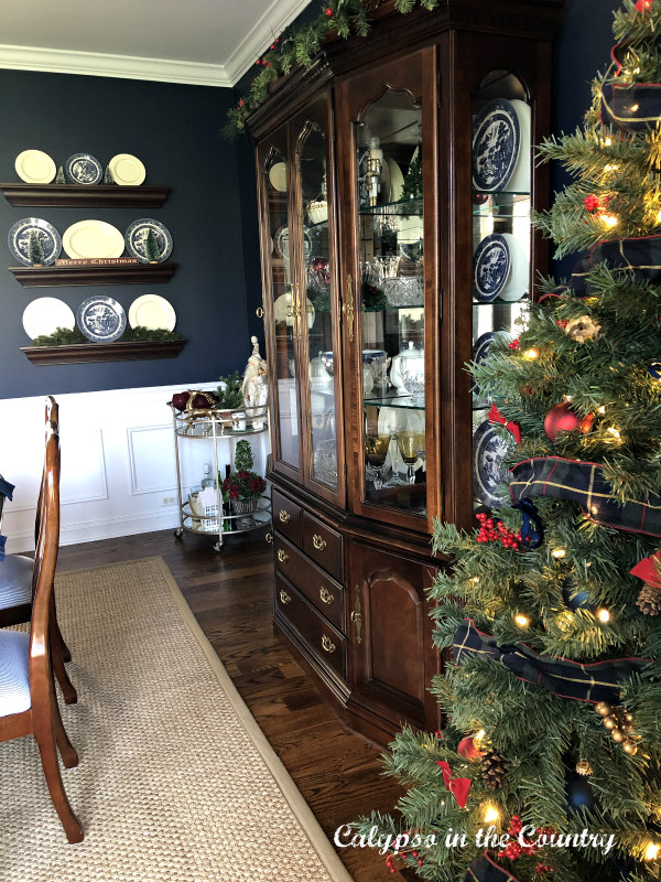 Red and Blue Christmas Tree next to china cabinet