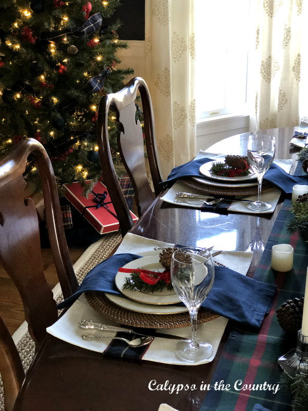 Red and Blue table setting with Christmas tree in background