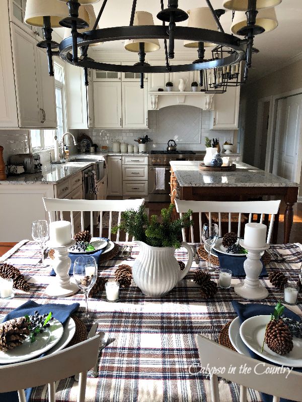 Table set with plaid tablecloth and pine cones - simple cozy winter tablescape