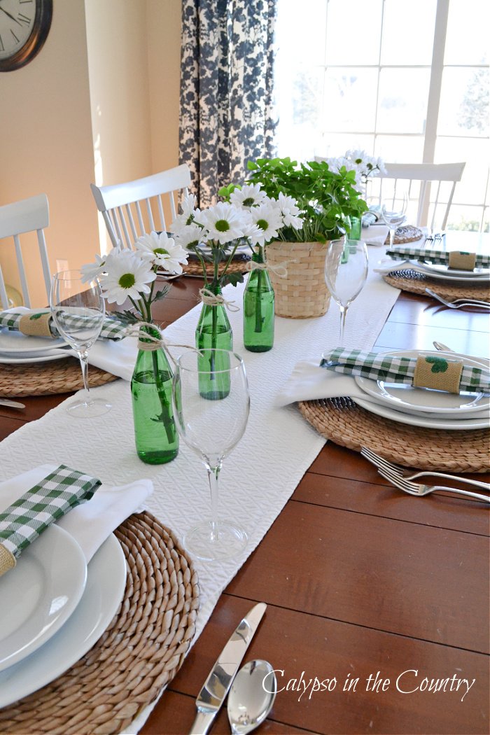 St. Patricks Day Table setting with green bottles and white table runner