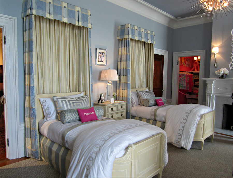 Twin beds in blue bedroom with fabric headboards and bright pink throw pillows