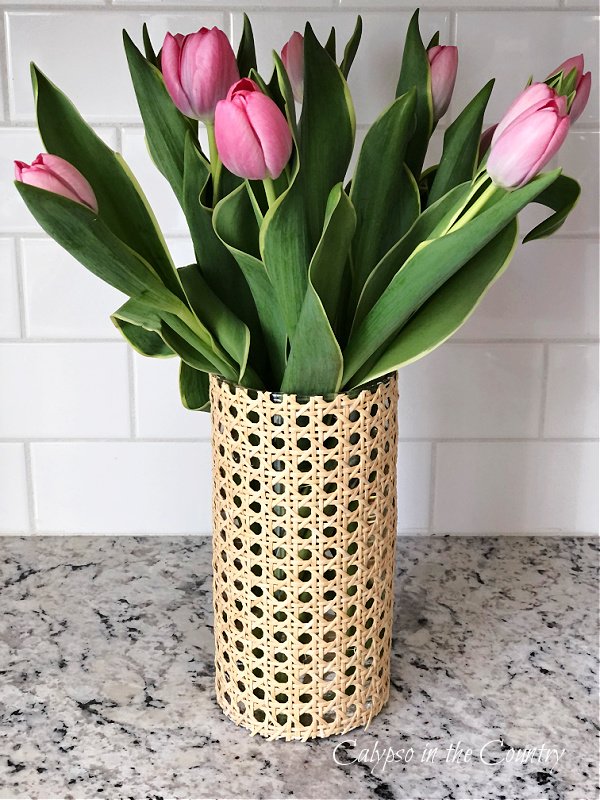 Cane wrapped vase filled with pink tulips