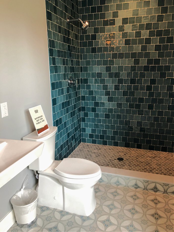 Blue shower tile in bathroom with patterned floor - modern farmhouse tour