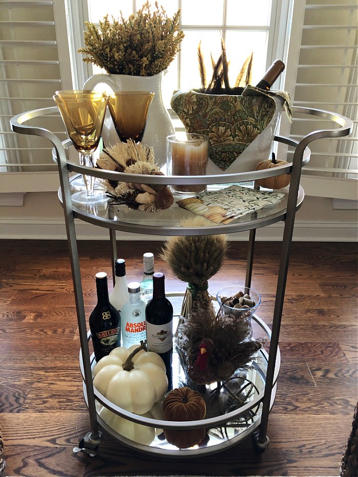 Round bar cart with green and gold accessories