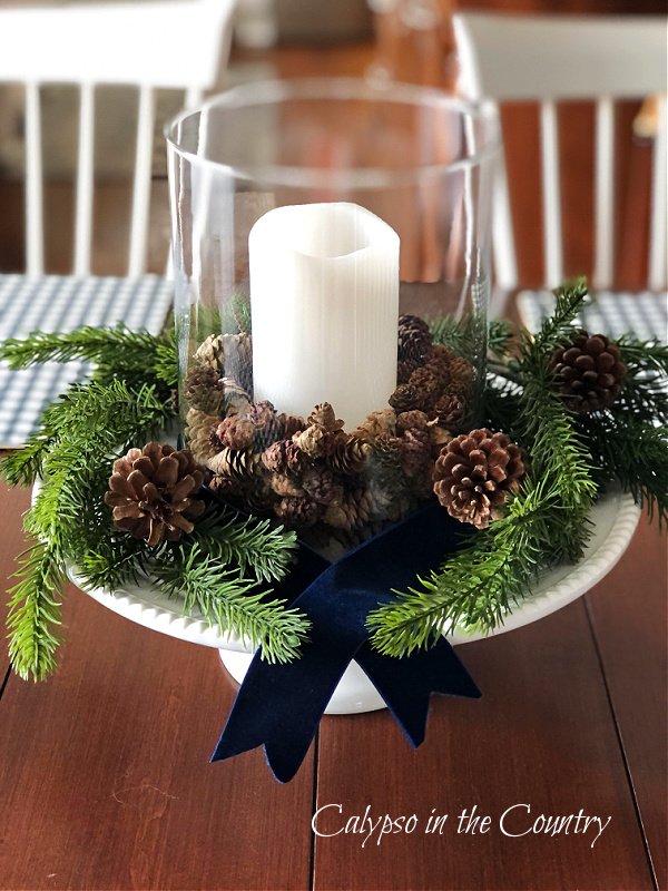 pine cones and candle in glass hurricane for Christmas