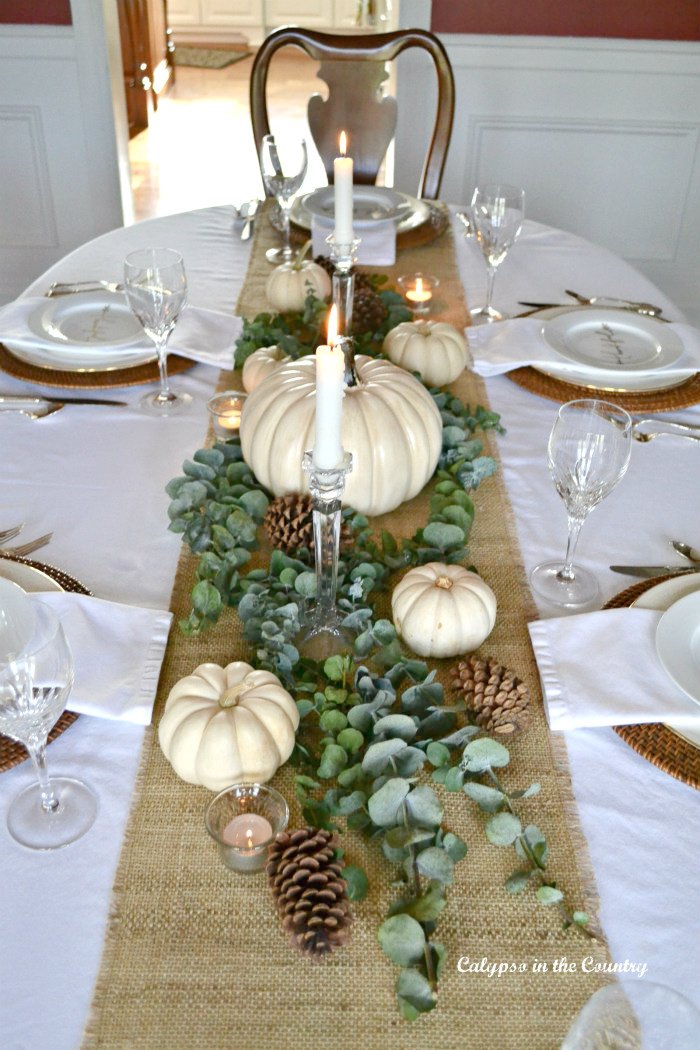 White pumpkins and eucalyptus on burlap runner - Thanksgiving centerpiece ideas