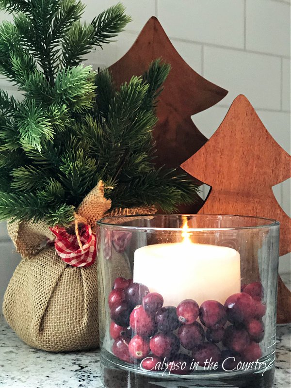 cranberries and candle in glass vase - easy vase filler ideas for Christmas