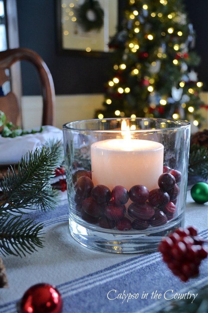 Candle with cranberries and Christmas tree lights