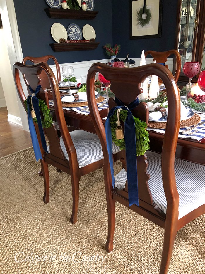 Mini wreaths and navy velvet ribbon on back of chairs - decorating with wreaths for Christmas 