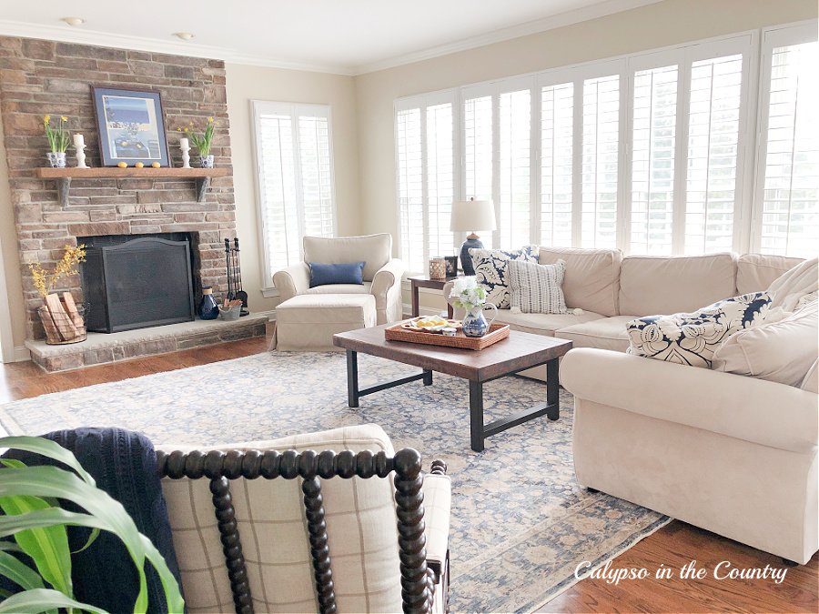 family room with sectional, plantation shutters and stone fireplace - spring decorating ideas