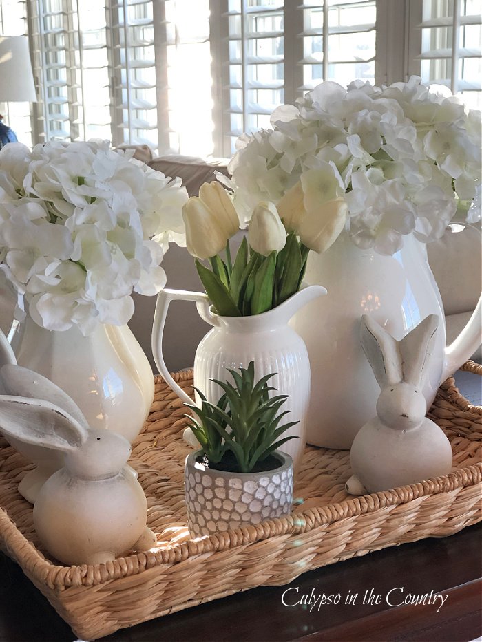 White pitchers and flowers on seagrass tray - Easter decorations ideas