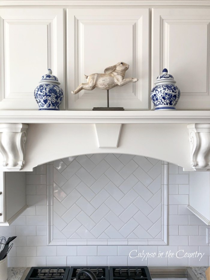 Bunny and blue and white ginger jars on stove mantel